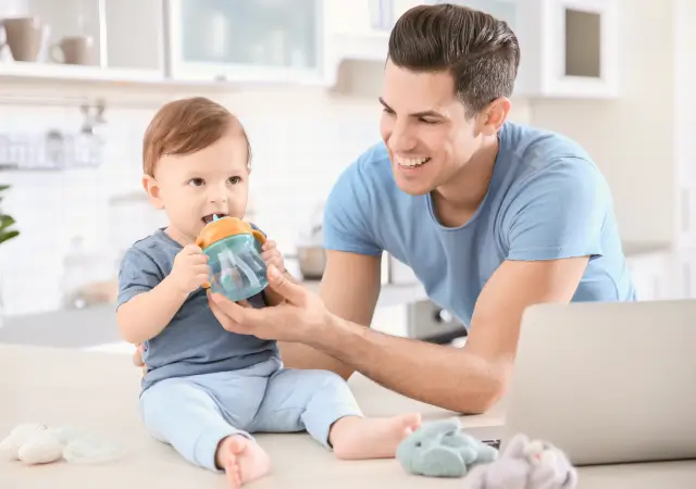 Papá dando algo de tomar a su bebé