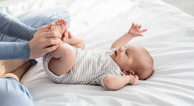 Mamá jugando con los pies de su bebé