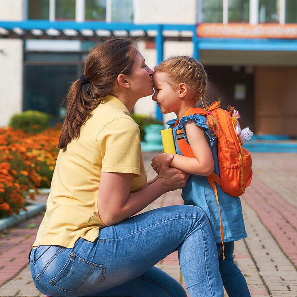 Mamá llevando a la niña al colegio