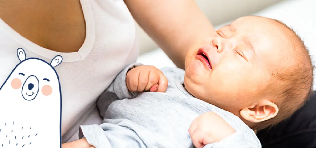 Madre sosteniendo a su bebé que llora por cólico